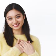 Close-up portrait cute and lovely asian girl press hands to heart, looking thankful and pleased, smiling as receive heartwarming gift, thanking being grateful, standing white background Body Massage Bandung