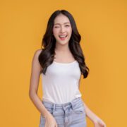 casual-happiness-asian-female-woman-smiling-cheerful-white-tshirt-blue-jean-relax-peaceful-positive-thinking-carefree-lifestyle-standing-with-yellow-color-background-studio- Pijat Online Bandung