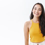 Cheerful young brunette asian girl in stylish yellow top enjoy v Pijat Plus Bandung
