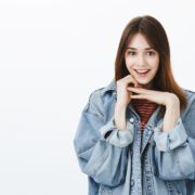 Charming girlfriend listening curiously interesting story. Portrait of pretty happy brunette in stylish denim jacket, holding hands above chin and smiling broadly, excited hearing amazing news Massage Refleksi Palembang